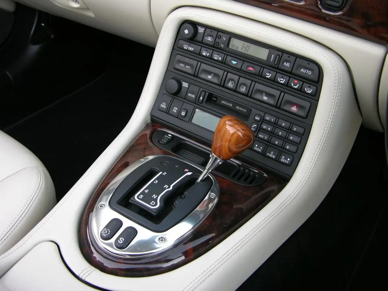 In this image we can see a car gear, here are the buttons on it.