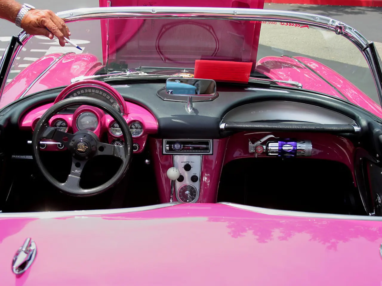 In this picture there is a pink color vehicle which has a steering and some other objects in it and...