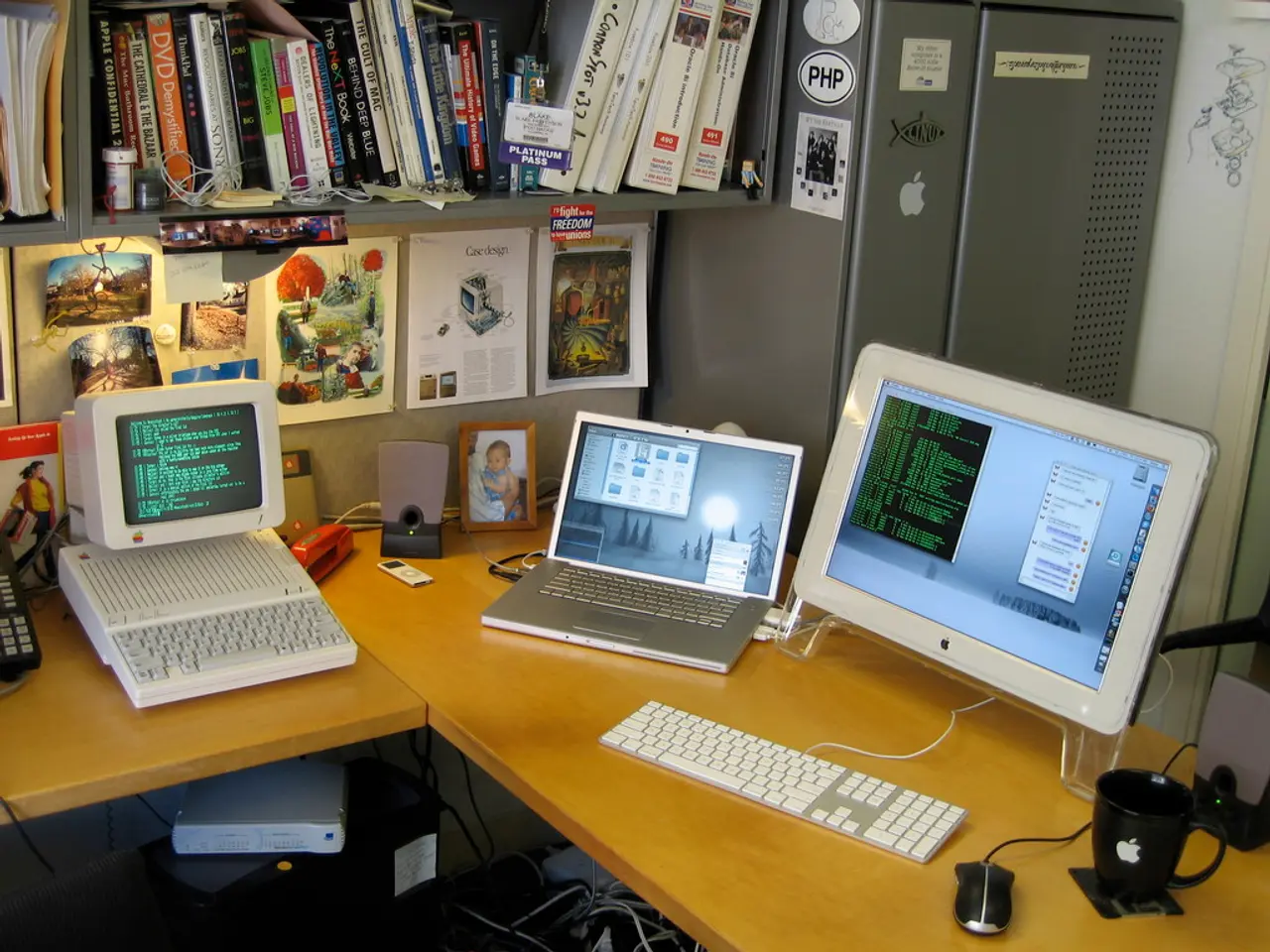 This is the wooden table with a monitor,key board,mouse,laptop,computer,speaker,photo frame,a cup...