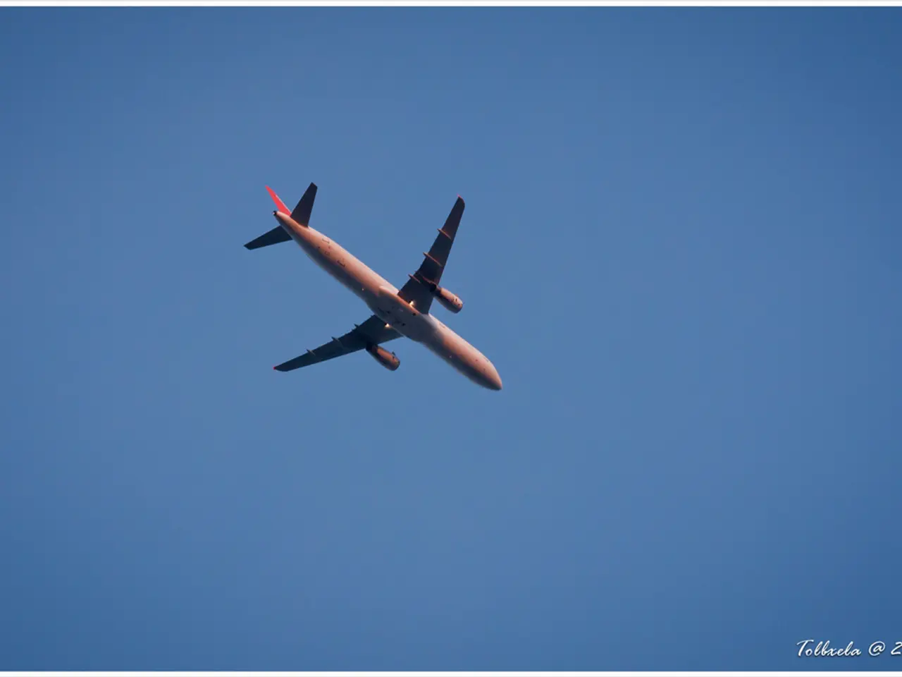 In this image, I can see an airplane flying in the sky. The background looks blue in color. This is...