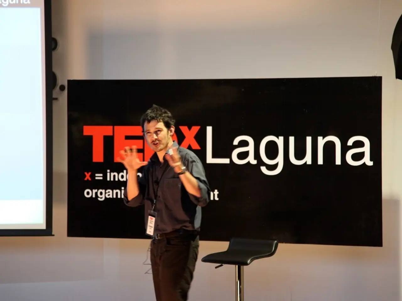 Here we can see a man in the middle speaking something and behind him we can see a chair and the...