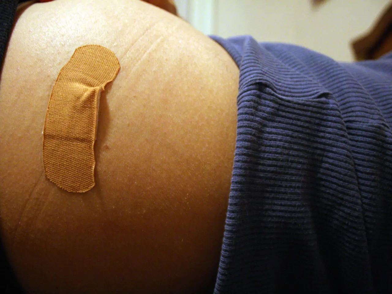 In this image, I can see a first aid plaster on the body of a person. There is a blurred...