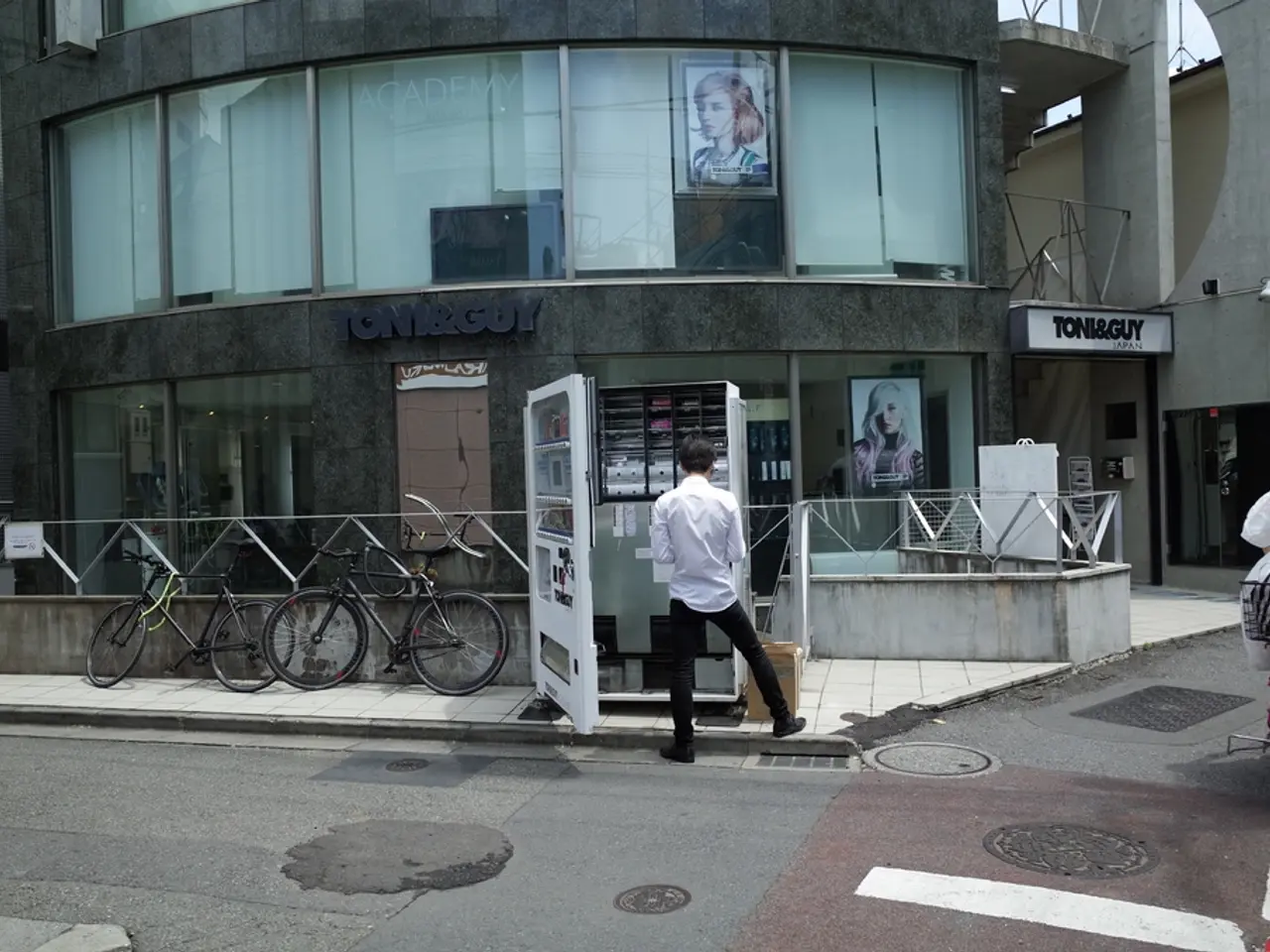 This is a road. Here we can see one woman riding a bicycle. We can see one man standing near to a...