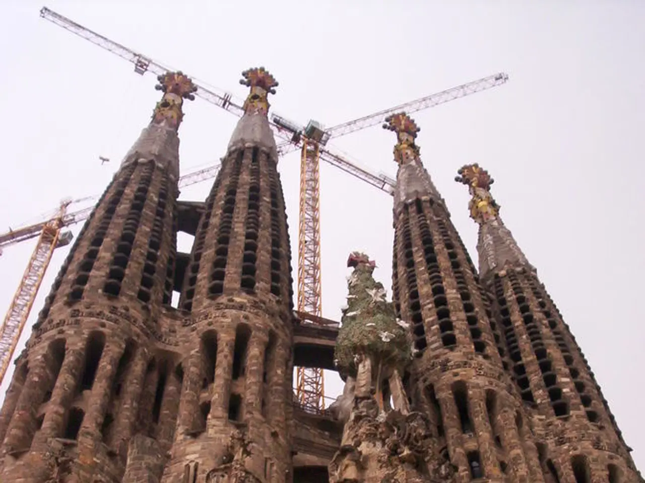 In the picture I can see a building, towers and jobs. In the background I can see the sky.