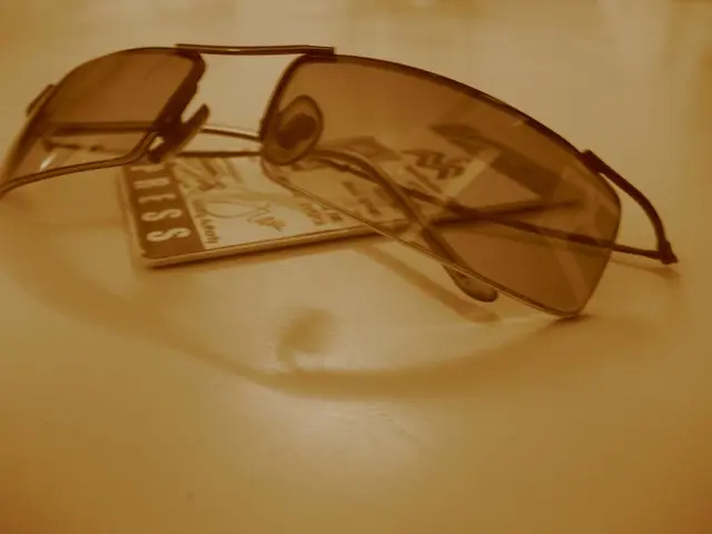 This Picture shows sunglasses and a id card on the table.