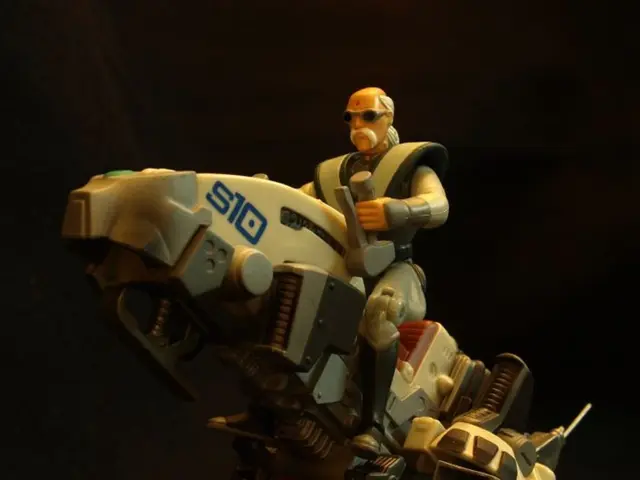 In this image in the front there is a toy car and there is a toy robot sitting on the car.