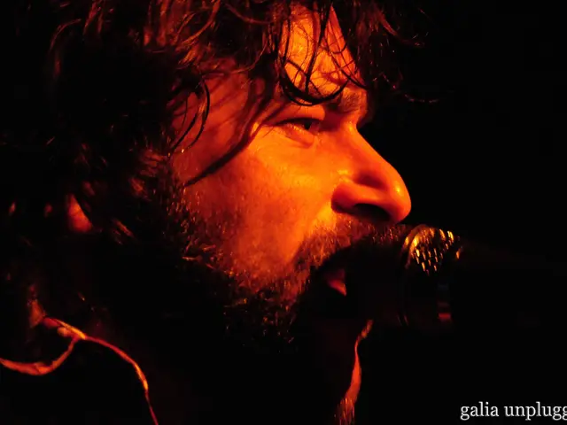 In this picture I can see a man in front and I can see a mic on the right side of this picture and...