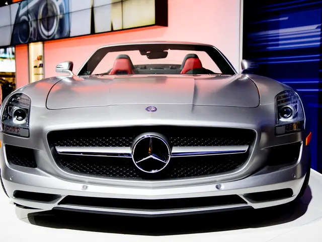 In this picture we can see few cars, in the background we can find a digital screen on the wall.