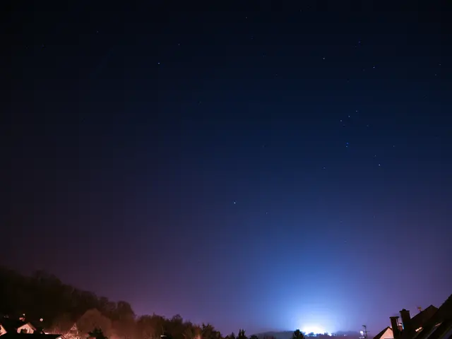 This is an image clicked in the dark. At the bottom of the image I can see few buildings, trees and...