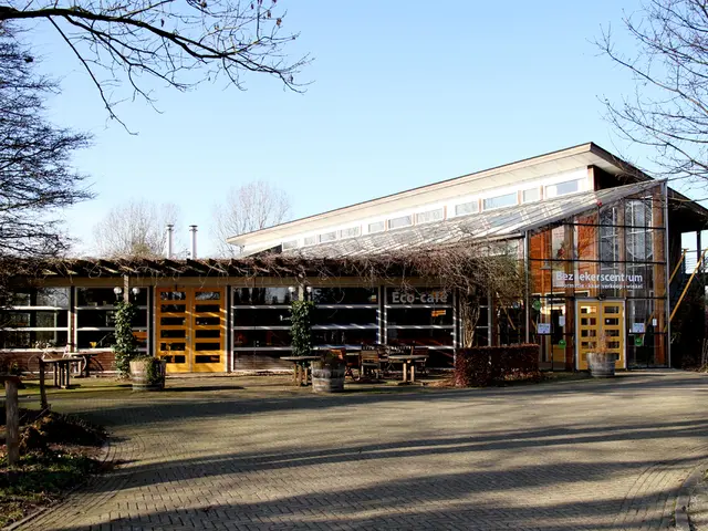 As we can see in the image there are buildings, trees, plants, tables and sky.