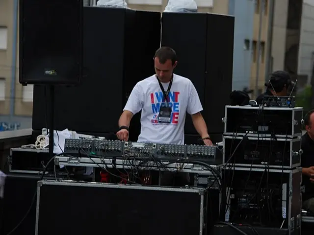 In this image we can see a person wearing white color T-shirt wearing Id card operating DJ and at...