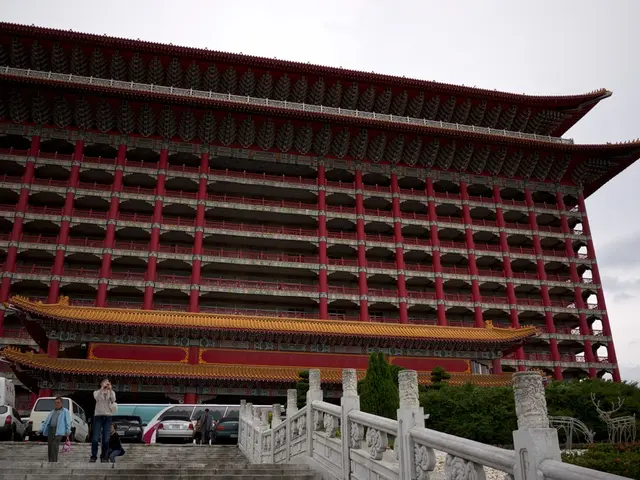 In the picture we can see a building which is constructed in the Japanese style and it is red in...